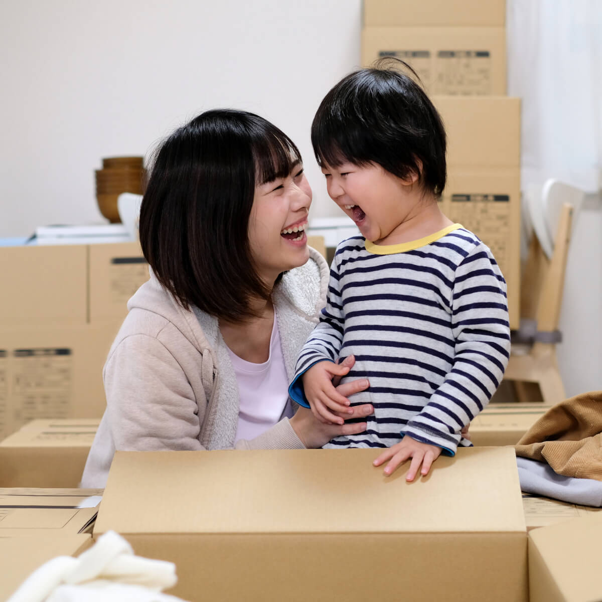 Mother and child surrounded by boxes moving into their new home. Housing rights